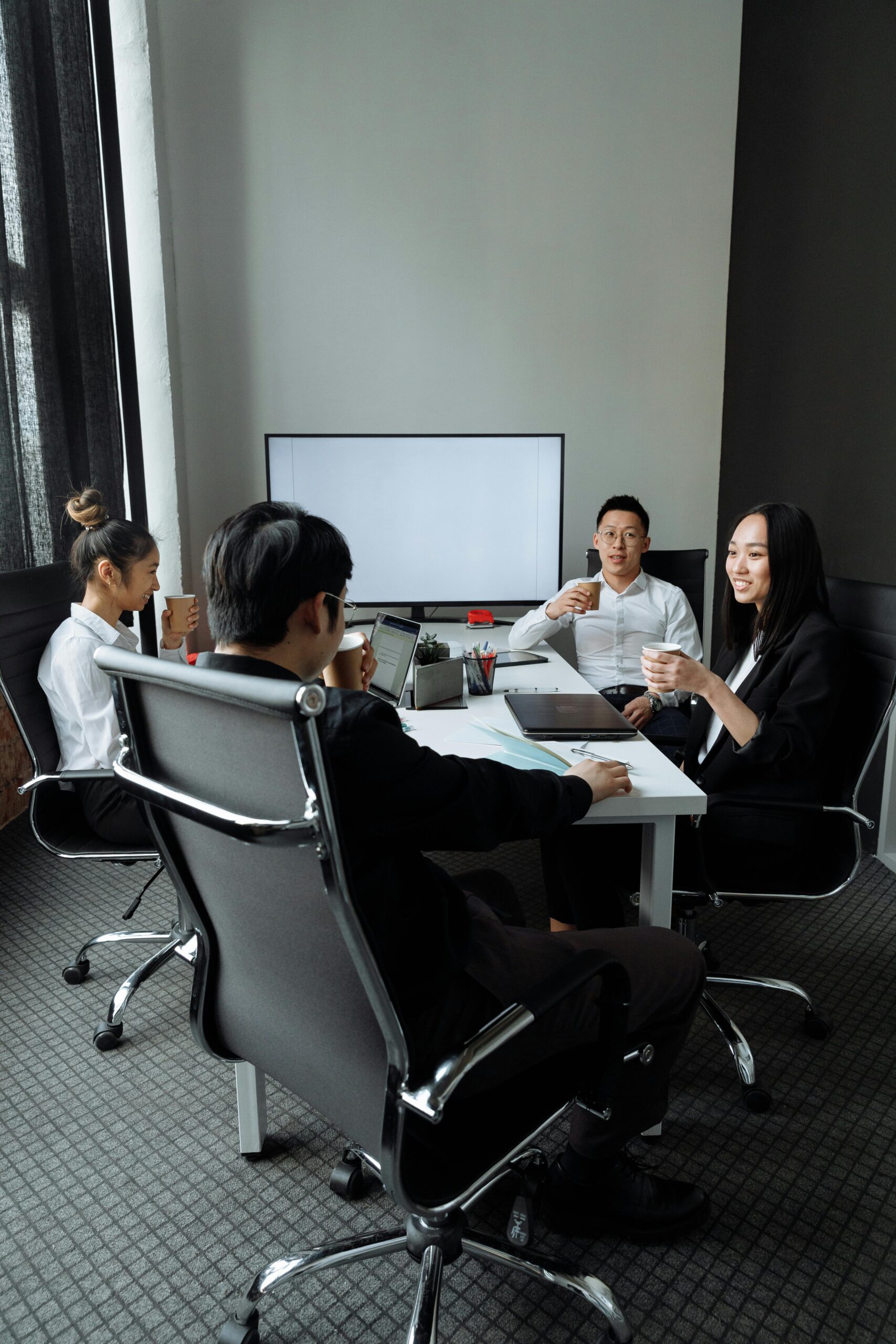 Group of professionals engaged in a collaborative meeting in a modern office setting.